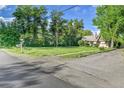 View of the house with a large grassy lawn and mature trees at 1930 Hoyt St, Lakewood, CO 80215