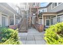 Open-air courtyard with stair access to units, brick accents, and well-manicured shrubs at 6001 S Yosemite St # H204, Greenwood Village, CO 80111
