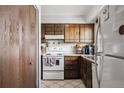 Traditional kitchen with wooden cabinets, white appliances, and ample counter space at 2567 Rainbow Dr # 80, Denver, CO 80229
