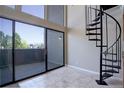 A spacious living room featuring sliding glass doors and a unique spiral staircase at 6490 S Dayton St # L10, Englewood, CO 80111