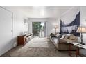 A bright living room featuring a sliding glass door to a balcony with views at 5995 W Hampden Ave # 20B, Denver, CO 80227