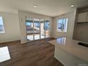 Open floor plan living room with hardwood floors, large sliding glass doors, and lots of natural light at 8205 Rockvale Dr, Littleton, CO 80125