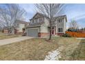 Traditional two-story home featuring a well kept front yard and red front door at 486 Balsa Dr, Castle Rock, CO 80104