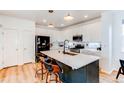 Modern kitchen with white cabinets, subway tile backsplash, stainless steel appliances, and a large center island at 3353 Wabash St, Denver, CO 80238
