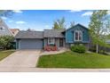 Charming exterior with blue siding, stone accents, and a well-manicured lawn and features two red Adirondack chairs at 21524 E Powers Pl, Centennial, CO 80015