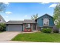Charming exterior with blue siding, stone accents, and a well-manicured lawn and features two red Adirondack chairs at 21524 E Powers Pl, Centennial, CO 80015