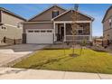 Inviting home with a covered porch, manicured lawn, and a two-car garage under a clear blue sky at 27694 E Byers Ave, Aurora, CO 80018