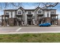 Townhome complex with brick and siding exterior, multiple stories, and a blue car parked outside at 1312 Independence St # 3, Lakewood, CO 80215