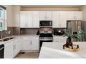 Modern kitchen features white cabinetry, stainless steel appliances, and a stylish backsplash at 1312 Independence St # 3, Lakewood, CO 80215