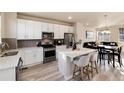Modern kitchen featuring white cabinetry, stainless steel appliances, and an island with breakfast bar at 1312 Independence St # 3, Lakewood, CO 80215