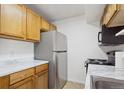 Galley kitchen with wood cabinets and appliances at 906 S Peoria St, Aurora, CO 80012