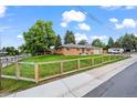 Beautifully maintained brick home with a lush green lawn and sturdy wooden fence at 5320 W 62Nd Ave, Arvada, CO 80003