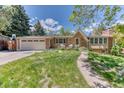 Inviting single-Gathering home with a well-kept lawn, attached garage, and brick accents at 879 S Cole Dr, Lakewood, CO 80228