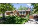 A beautiful brick home with a well-maintained lawn, mature trees, and inviting curb appeal at 879 S Cole Dr, Lakewood, CO 80228