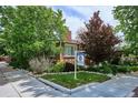 Charming brick home featuring a lawn and attractive landscaping. Real estate sign visible at 4000 Irving St, Denver, CO 80211