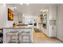 Open-concept kitchen with granite countertops, an island with bar stools, and stainless steel appliances at 4074 S Poplar Way, Denver, CO 80237