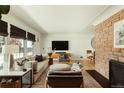 Bright living room features a brick fireplace, modern decor, and hardwood floors at 2060 Kline St, Lakewood, CO 80215