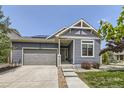 Inviting front exterior with blue siding, well-manicured lawn, and a two-car garage at 12993 E 108Th Ave, Commerce City, CO 80022