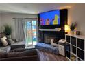 Cozy living room with a stone fireplace and sliding glass doors to the backyard at 15507 E Louisiana Ave, Aurora, CO 80017