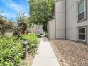 Peaceful walkway alongside the condo building with lush greenery and gravel accents at 7318 S Xenia Cir # B, Centennial, CO 80112