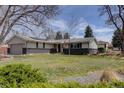 View of the home, highlighting its well-kept lawn, brick accents, and inviting entrance, all under a partly cloudy sky at 6272 S Garfield Dr, Centennial, CO 80121