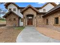 Inviting stone and stucco home with a grand wooden front door and charming entryway at 11790 Huckleberry Dr, Franktown, CO 80116