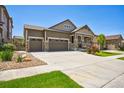 Beautiful home with a three-car garage, stone accents, a welcoming front porch, and manicured front yard at 17056 E 111Th Ave, Commerce City, CO 80022