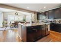 Modern kitchen featuring dark wood cabinets, granite countertops, stainless steel appliances and eat-in dining area at 17056 E 111Th Ave, Commerce City, CO 80022