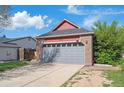 A well maintained two-car garage and driveway for a charming brick and red siding home at 7598 Jared Way, Littleton, CO 80125
