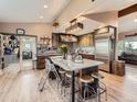 Bright kitchen featuring a large kitchen island with seating, stainless steel appliances, and an open layout at 50950 E 32Nd Ave, Bennett, CO 80102