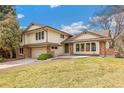 Attractive two-story home featuring a brick facade, manicured lawn, and an attached two-car garage at 7743 S Birch Ct, Centennial, CO 80122