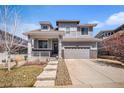 Well-maintained two-story home featuring a covered porch, gray siding, and a two-car garage at 26903 E Easter Pl, Aurora, CO 80016
