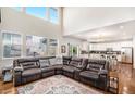 Open-concept living space featuring hardwood floors and a connected modern kitchen at 26903 E Easter Pl, Aurora, CO 80016