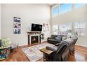 Bright living room with a cozy fireplace, hardwood floors, and a soaring vaulted ceiling at 26903 E Easter Pl, Aurora, CO 80016