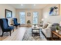 Bright living room featuring wood floors, a cozy sofa, and stylish blue chairs, perfect for relaxing or entertaining at 1699 S Trenton St # 172, Denver, CO 80231