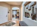 Inviting entryway featuring an arched doorway, hardwood floors, and decorative niche with elegant accents at 10968 Macon St, Commerce City, CO 80640