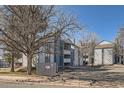 Multi-story apartment complex with gray siding and well-maintained landscaping offers comfortable living at 14066 E Stanford Cir # H08, Aurora, CO 80015