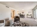 Bright living room featuring neutral decor, plush carpet, and a dining area with seating at 14066 E Stanford Cir # H08, Aurora, CO 80015