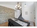 Dining room with decorative lighting, staircase, stone accent wall, and hardwood floors at 6725 Lionshead Pkwy, Lone Tree, CO 80124