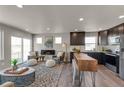 Bright living area featuring a modern fireplace, stylish seating, and an open layout to the kitchen at 46501 Avery Ln, Bennett, CO 80102