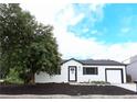 Charming single-story home with white siding, black trim, well-maintained landscaping, and a lovely front yard tree at 10792 Moore St, Broomfield, CO 80021