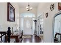 Welcoming foyer with hardwood floors, an ornate chandelier, and a decorative front door at 38025 E 145Th Pl, Keenesburg, CO 80643