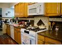 Traditional kitchen with wooden cabinets, granite countertops, tile backsplash, and modern white appliances at 1375 N Iola St, Aurora, CO 80010