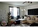Cozy living room with sectional sofa, decorative wall art, and bright natural light from the large window at 1375 N Iola St, Aurora, CO 80010