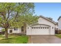 Charming home featuring an attached two-car garage and a well-maintained front lawn at 12507 Dexter Way, Thornton, CO 80241