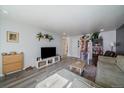 Bright living room featuring a large TV, stylish shelving, and an open layout at 10321 W 59Th Ave # 2, Arvada, CO 80004