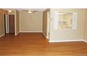 Open living room with wood floors connected to doorway and window to the bright kitchen at 14390 E Marina Dr # 204, Aurora, CO 80014