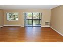Bright living room featuring wood floors, large window, and sliding glass door to a private balcony at 14390 E Marina Dr # 204, Aurora, CO 80014