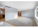 Spacious living room with neutral carpet ready for your personal design at 10636 Ura Ln, Northglenn, CO 80234