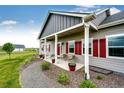 Charming covered front porch with stylish columns, red shutters, and cozy seating, enhancing curb appeal at 196 W 8Th Ave, Byers, CO 80103